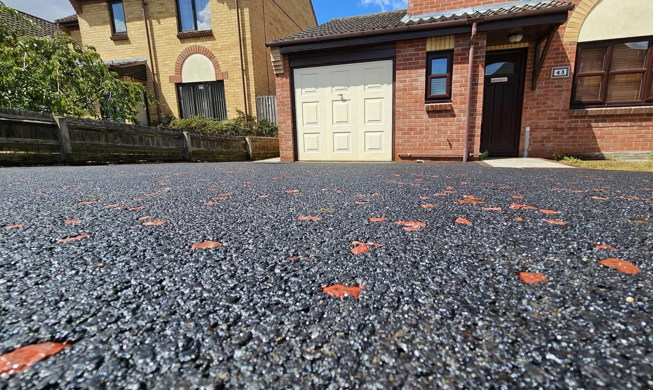 Close-up of tarmac driveway with red chippings